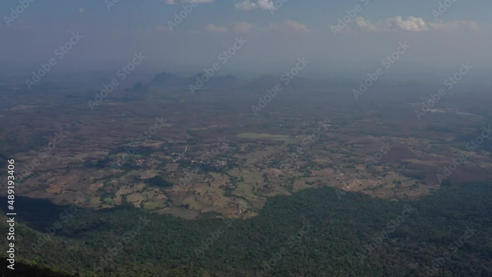 Slow motion shot, Beautiful landscape aerial view in tropical forest - Birds eye view use the drone see the habitation in valley with fog and cloud on sky Slow motion shot, Beautiful landscape aerial view in tropical forest - Birds eye view use the drone see the habitation in valley with fog and cloud on sky