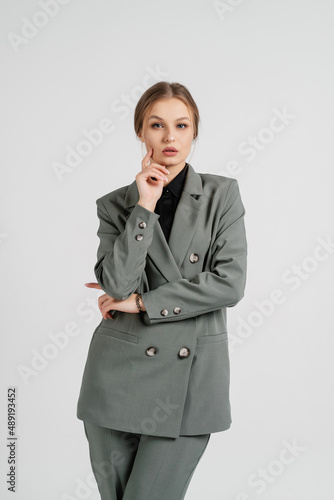 Young beautiful woman posing in a business suit. Employee and business concept.
