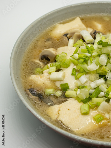 A bowl of shallot, tofu and mushroom soup