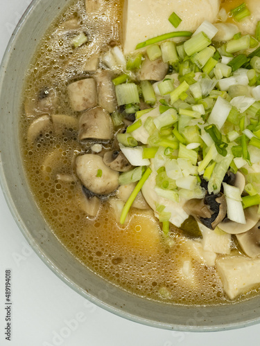 A bowl of shallot, tofu and mushroom soup