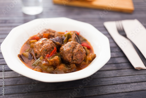 cooked meatballs with stewed eggplant in bowl