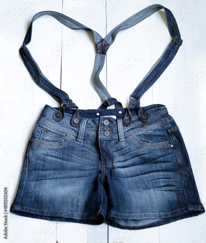 Denim shorts with suspenders on a white background