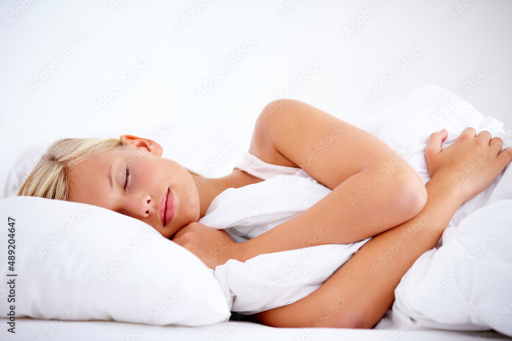 Getting some beauty sleep. Gorgeous young woman peacefully sleeping comfortably on white linen. Getting some beauty sleep. Gorgeous young woman peacefully sleeping comfortably on white linen.