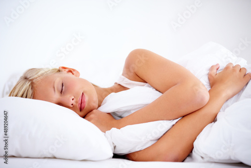 Getting some beauty sleep. Gorgeous young woman peacefully sleeping comfortably on white linen.