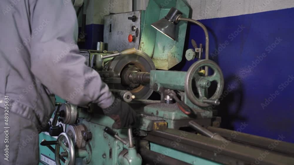 Worker Behind a Lathe Turning an Automotive Part Worker Behind a Lathe Turning an Automotive Part