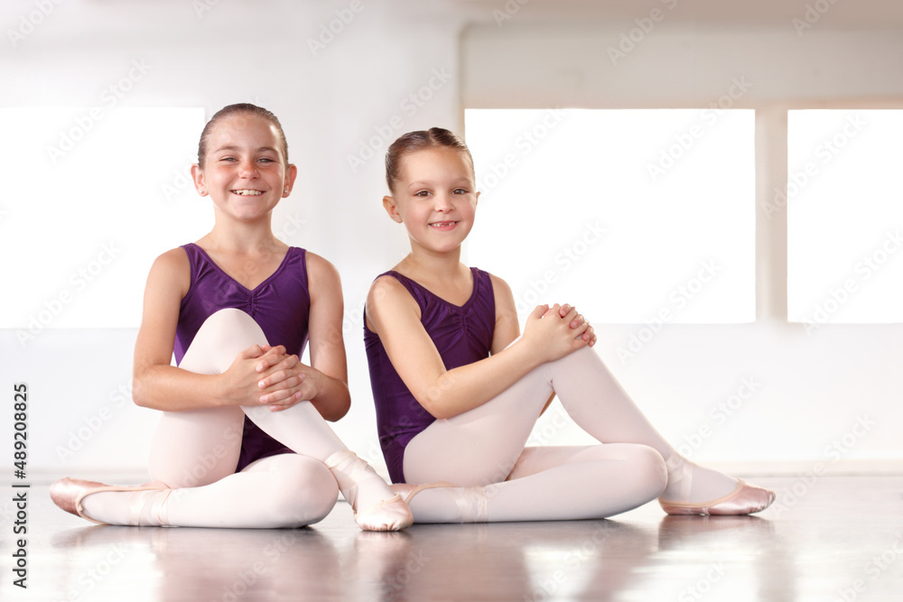 Obraz premium Ballerinas in the making. Happy young ballerinas sitting in a ballet studio.