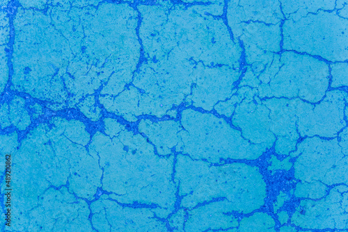 Cracks on blue paint concrete surface cracked weathered cement worn texture broken abstract damaged pattern background