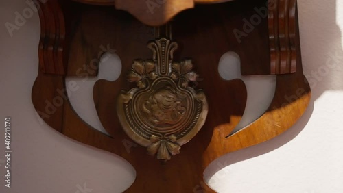Slow motion of wall clock pendulum
