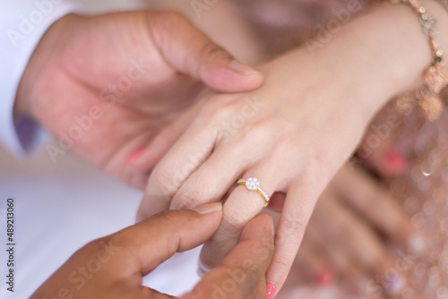 groom wears ring on bride's finger in wedding ceremony.wearing a ring at a wedding.feeling of love 