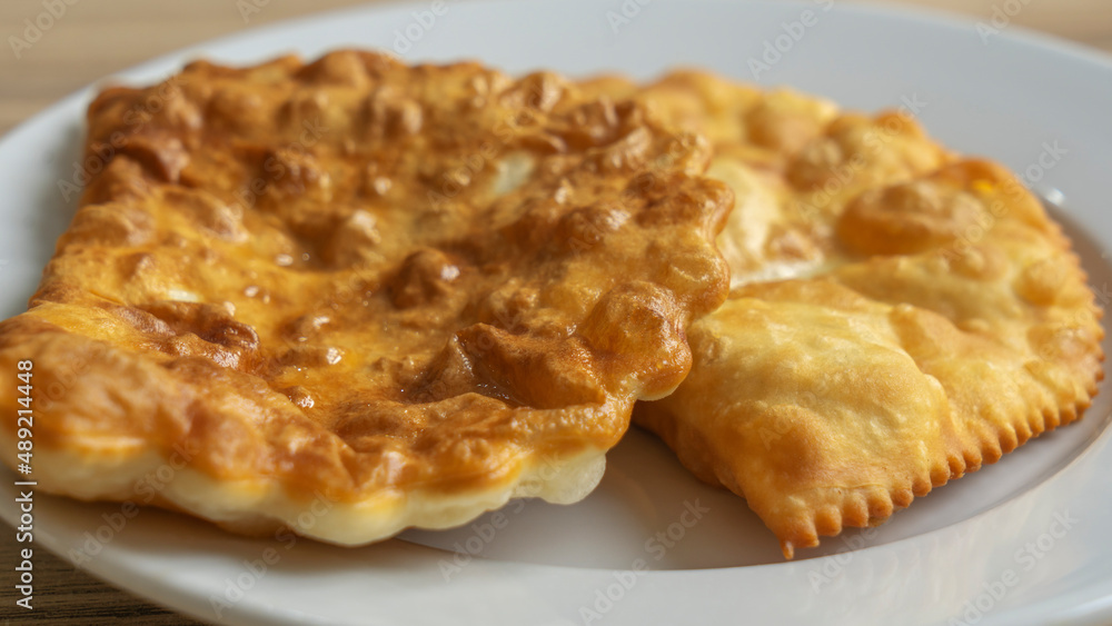 Homemade pasties with meat filling on white plate. traditional Caucasian and Russian cuisine. Take away food concepts Homemade pasties with meat filling on white plate. traditional Caucasian and Russian cuisine. Take away food concepts