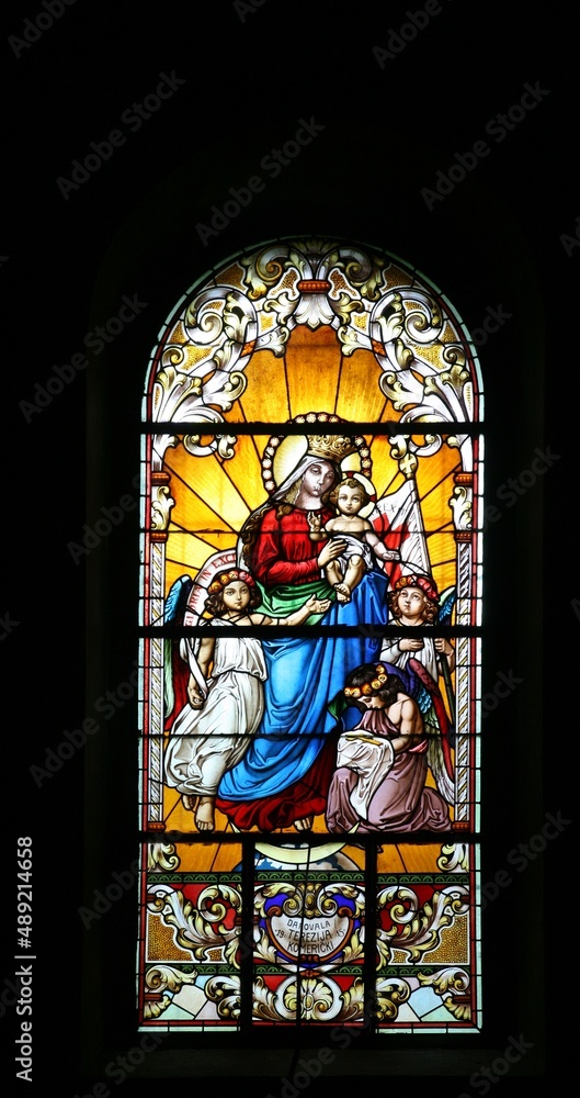 Virgin Mary with baby Jesus and Angels, stained glass window in the ...