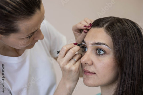 Marking eyebrows with brow paste, close-up.