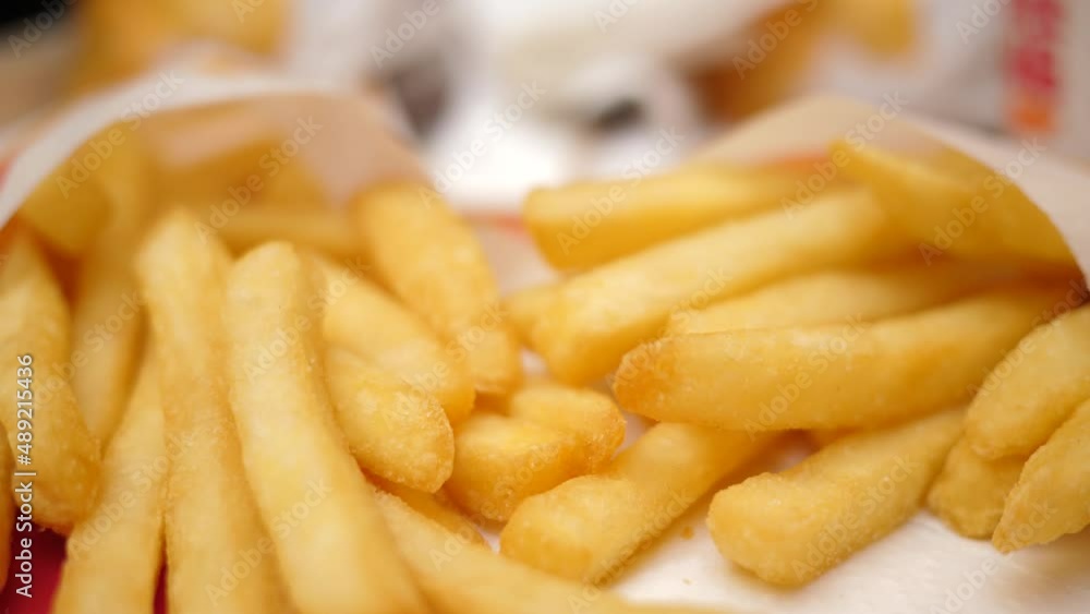 Closeup slow motion eating French fries fast food potatoes chips male fingers pick up a snack piece Closeup slow motion eating French fries fast food potatoes chips male fingers pick up a snack piece