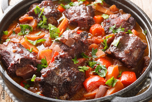 Obraz na płótnie Beef tail oxtail stew cooked in traditional spanish food rabo de toro closeup on a pot on the wooden table