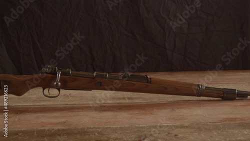 Dolly in of old K98 Mauser rifle standing on a wooden surface