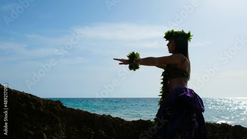 Beautiful hawaiian woman performing hawaiian dance happily barefoot on the beach