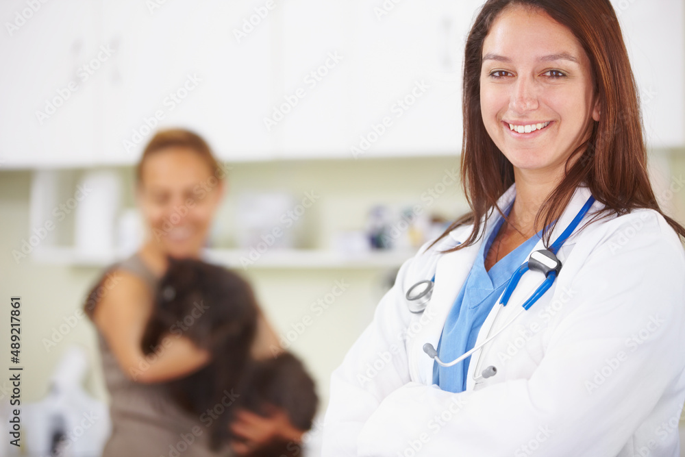 Another happy pet owner. A portrait of a smiling female vet with a pet owner and her cat int he background. Another happy pet owner. A portrait of a smiling female vet with a pet owner and her cat int he background.