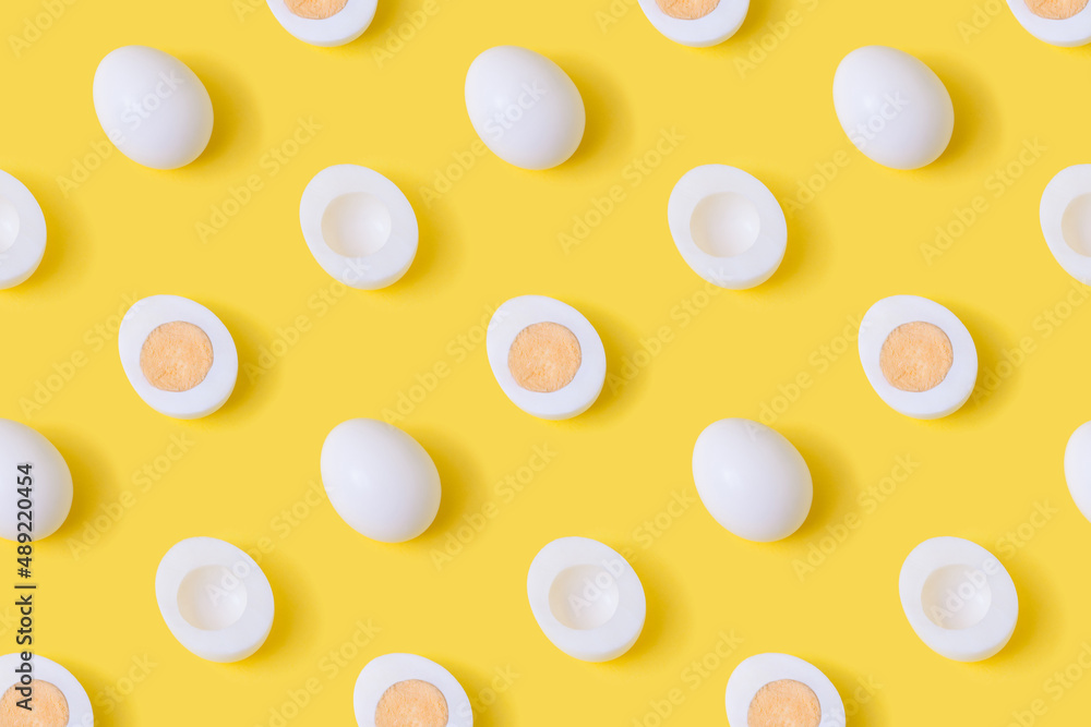 Trendy pattern made of sliced boiled eggs on pastel yelow background. Cool breakfast wallpaper. Trendy pattern made of sliced boiled eggs on pastel yelow background. Cool breakfast wallpaper.