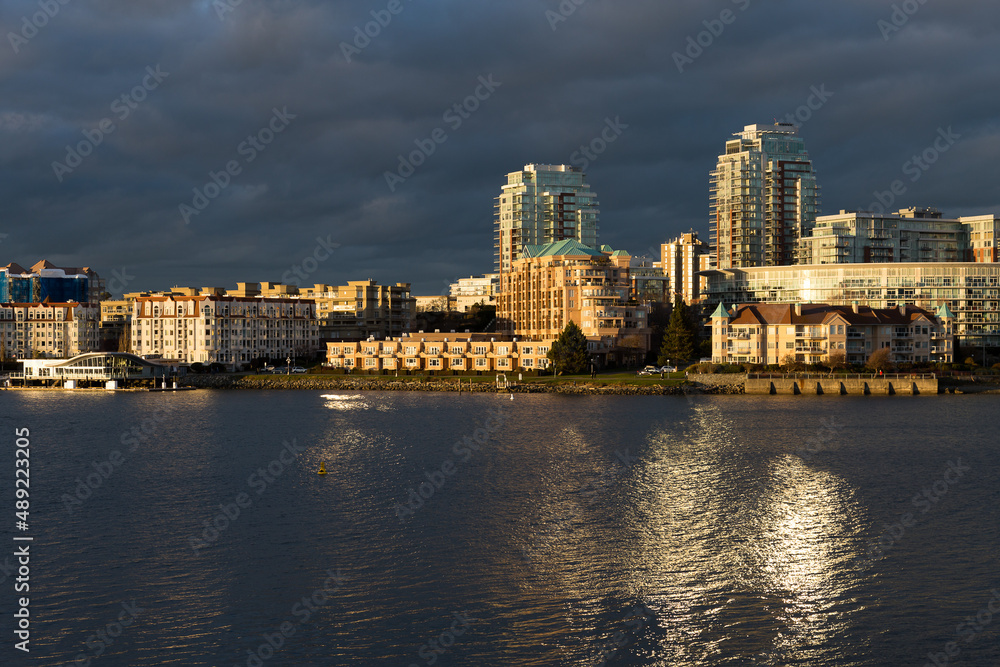 The inner harbour waterfront buildings illuminated by the sun during a dramatic golden hour evening, Victoria, British Columbia, Canada