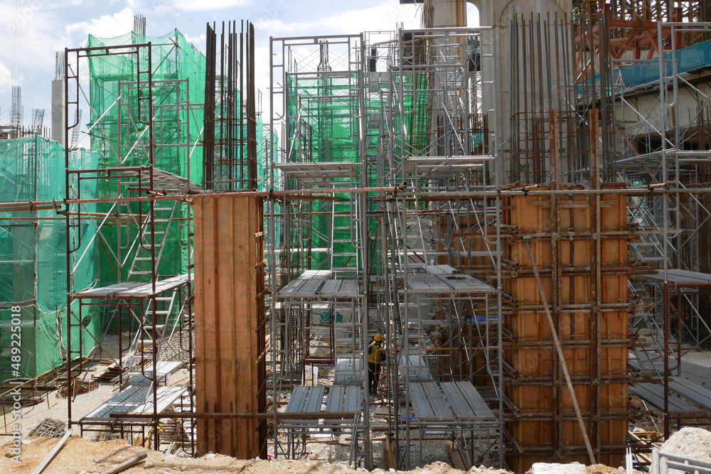 SELANGOR, MALAYSIA -JULY 17, 2021: Concrete columns are formed using timber and plywood formwork. Steel reinforcement is neatly installed inside before being poured with molten concrete.
