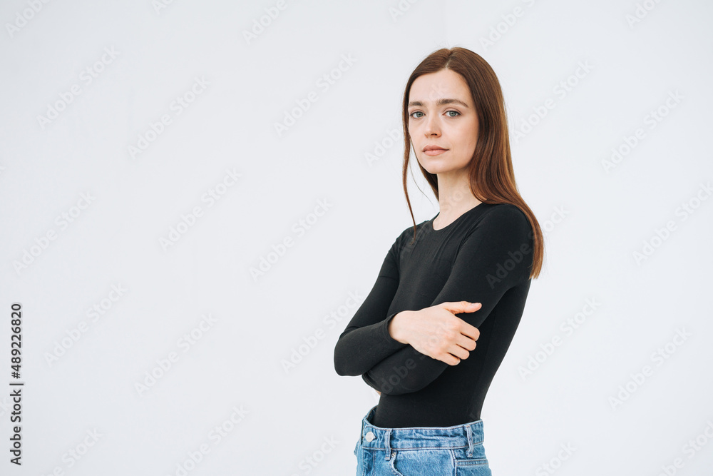 Portrait of thinking young beautiful woman in close pose with dark long hair in black longsleeve and jeans on the white background isolated Portrait of thinking young beautiful woman in close pose with dark long hair in black longsleeve and jeans on the white background isolated