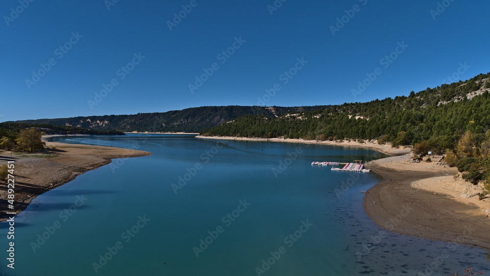 View of reservoir Lake of Sainte-Croix near the western edge of Verdon Gorge in Provence region, southern France on sunny day in autumn with boats.