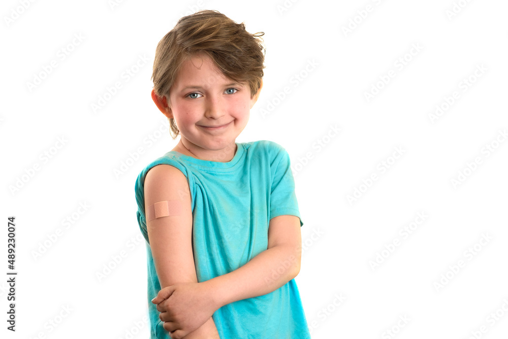 a happy boy showing his arm with bandage after got vaccinated. A emotional child with a band-aid on his hands, vaccinated against a coronavirus infection. Vaccination against COVID-19 a happy boy showing his arm with bandage after got vaccinated. A emotional child with a band-aid on his hands, vaccinated against a coronavirus infection. Vaccination against COVID-19