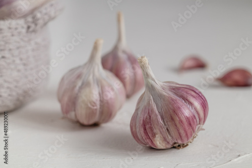 Organic purple garlic bulbs close up on a light table..