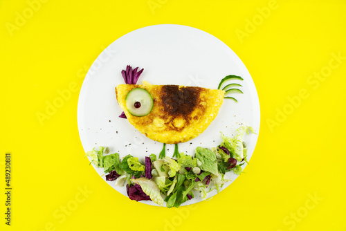 Funny chick egg omelette with vegetables and herbs for kids breakfast.