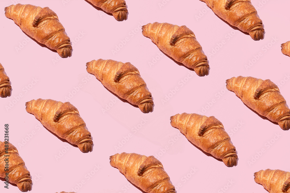 Traditional French pastry, croissants pattern against pastel pink background. The ultimate Parisian breakfast. Traditional French pastry, croissants pattern against pastel pink background. The ultimate Parisian breakfast.