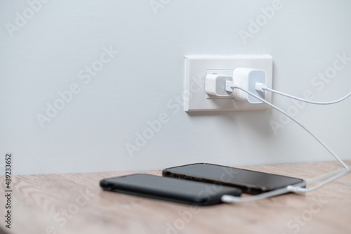 smart phone charger plugged on wooden with plugged at home. photo