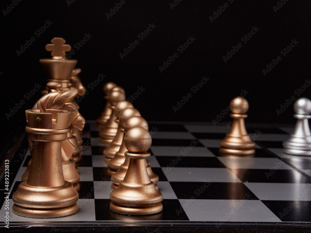 One chess piece stands against a full set of chess pieces. The concept of strategy, planning and decision-making One chess piece stands against a full set of chess pieces. The concept of strategy, planning and decision-making