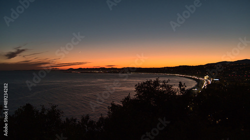 Beautiful aerial panoramic view over the mediterranean coast of city Nice, France at the French Riviera after sunset with famous beach.