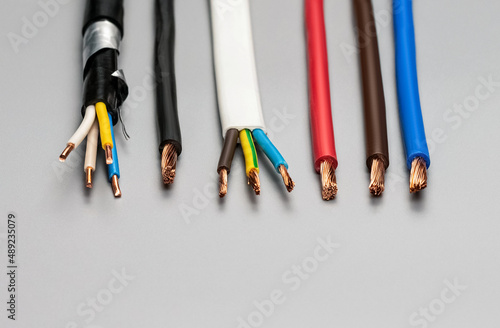 Different types of copper wires with insulation on a gray background