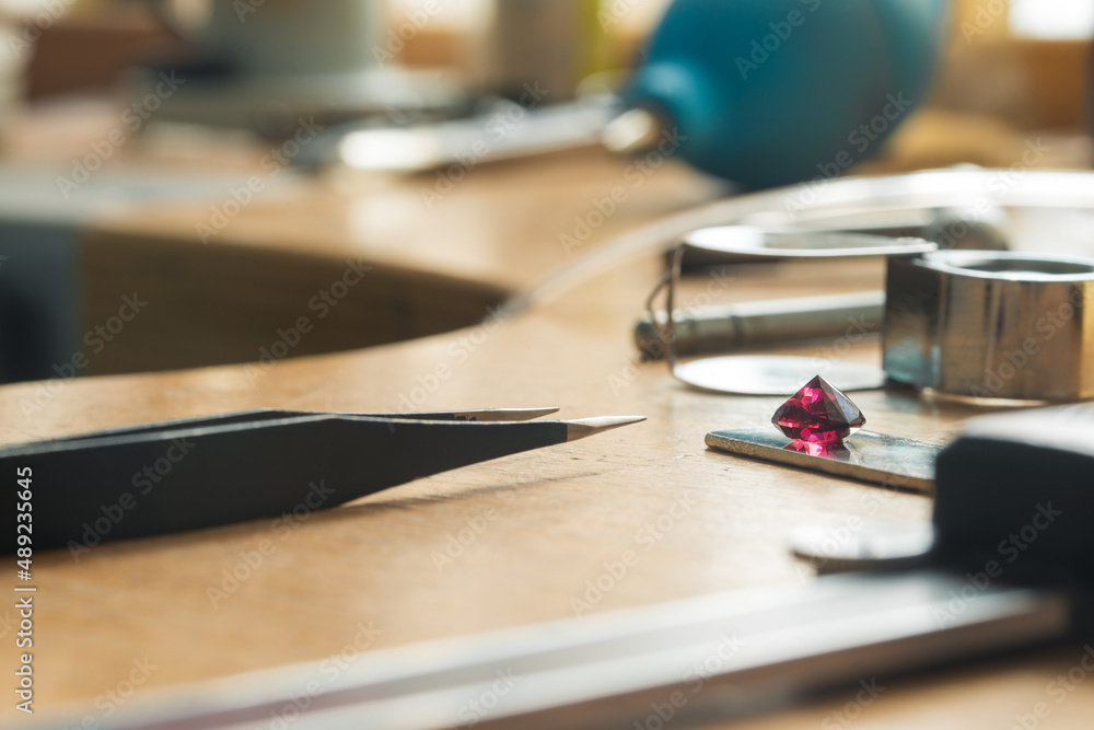 Tools and equipment for working on a black background. Ruby gemstone and jeweler equipments. Engraver at work on diamond jewelry Tools and equipment for working on a black background. Ruby gemstone and jeweler equipments. Engraver at work on diamond jewelry