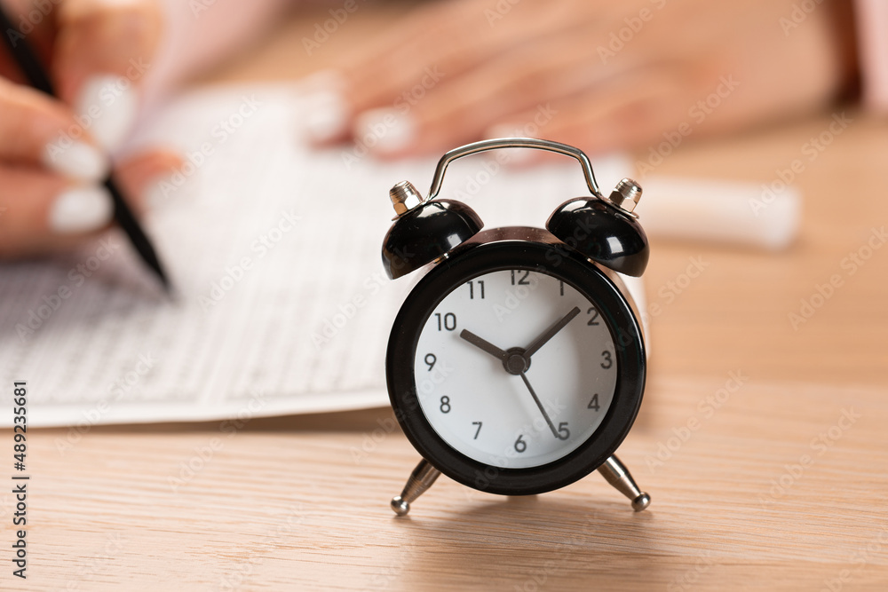 allotted time for exam and student hand testing in exercise and passing exam carbon paper computer sheet with pencil in school test room, education concept allotted time for exam and student hand testing in exercise and passing exam carbon paper computer sheet with pencil in school test room, education concept