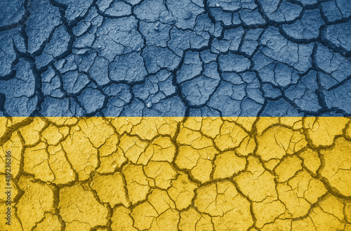 Ukrainian national flag pattern cracked earth, war concept photo