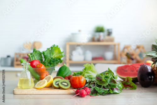 Fresh fruits and vegetables on wooden table in bright white kitchen, healthy lifestyle concept