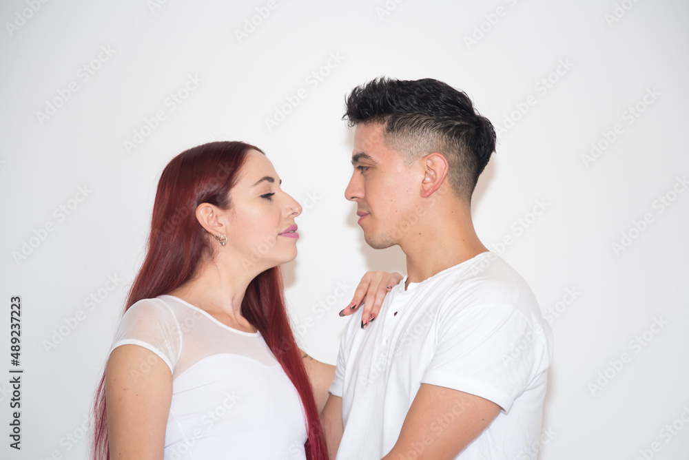 couple embracing, in love, with neutral background, dark-haired boy, red-haired girl couple embracing, in love, with neutral background, dark-haired boy, red-haired girl