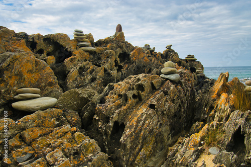 Small cairns made of smooth stones on a weathered rock at Cape Conran, Victoria, Australia 