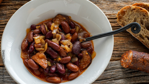 Bean and home sausage soup on rustis wooden table photo