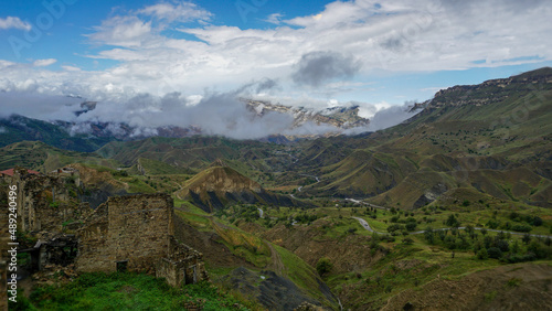 View of the town of Chokh with abandoned houses against the backdrop of a valley with mountains and clouds