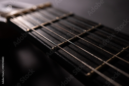 Classical guitar on black background. Acoustic guitar concept.Perfect for flyer, card, poster or wallpaper