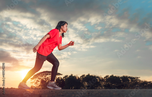 A woman is in preparation for running. Running is an exercise that can be done anywhere, anytime. Running strengthens your heart muscle and improves blood flow throughout your body.