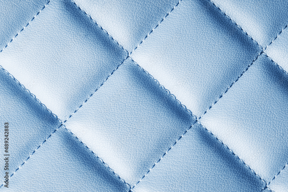 Fototapeta premium Blue leather texture. Macro fashion background. Women hand bag closeup backdrop. Grunge artificial pattern. Furniture thread sew.