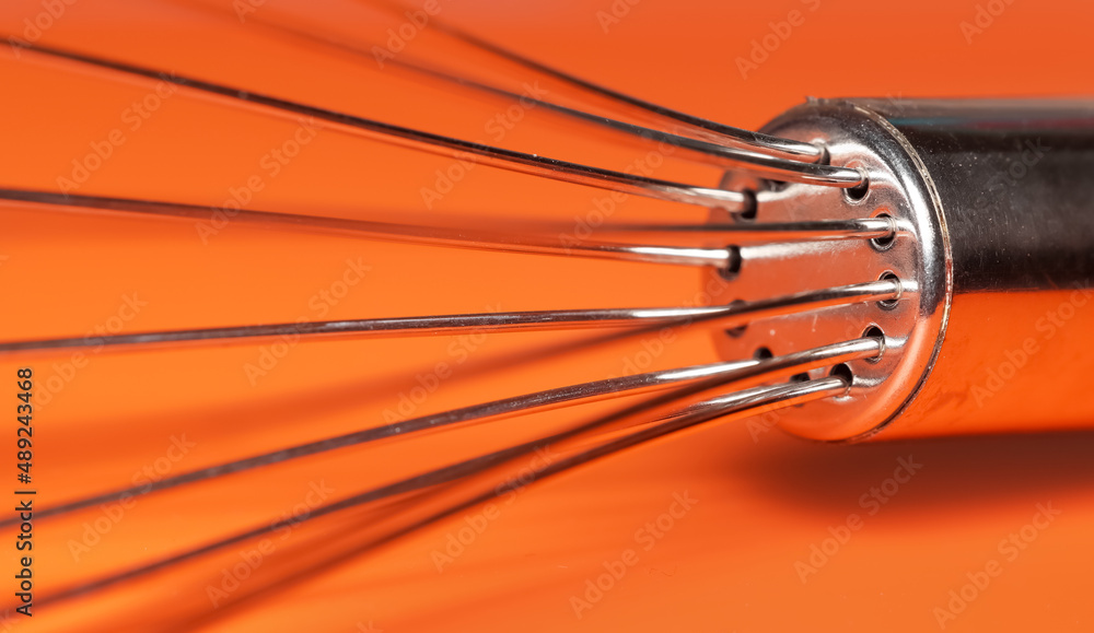 Close up shot egg beater on Orange background Close up shot egg beater on Orange background