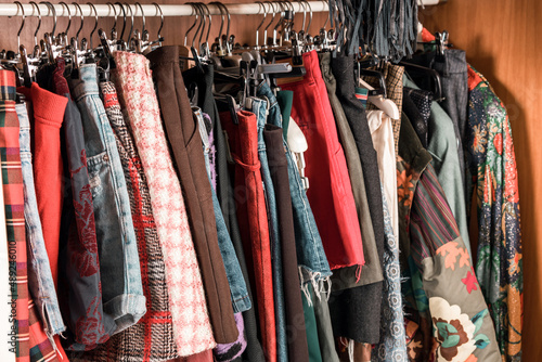 Assorted colorful female clothing hanging in a closet photo