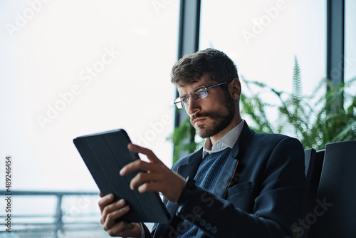business man thoughtfully looking at the screen of a digital tab