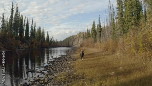 a hunter walking in alaska shot with a drone while hunting for moose in the wilderness out there into the wild