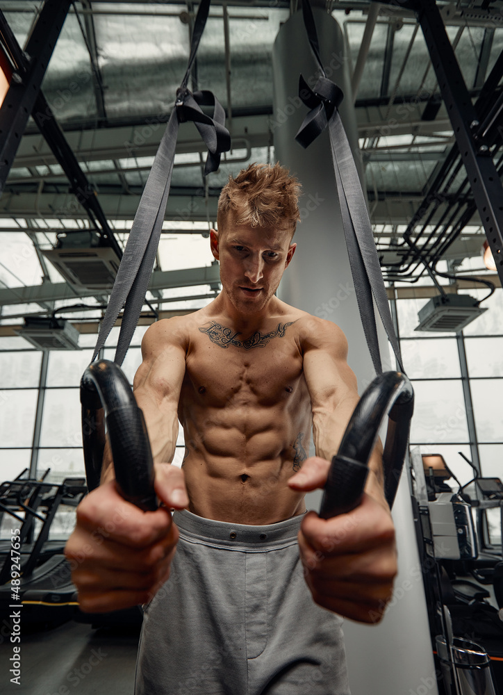 Muscle-up exercise young man doing intense cross fit workout at the gym on gymnastic rings. Muscle-up exercise young man doing intense cross fit workout at the gym on gymnastic rings.